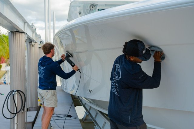 Platinum Coast Detailers technicians polishing a yacht hull in Naples, Florida